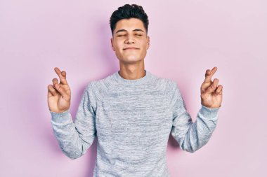 Günlük kıyafetler giyen genç İspanyol adam umut ve gözlerin kapalı gülümseyerek bana işaret etti. Şans ve batıl inançlar. 