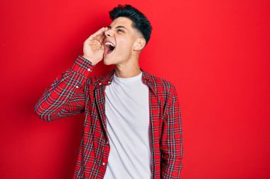 Latin asıllı genç adam günlük kıyafetler giyip el ele tutuşarak bağırıyor ve çığlık atıyordu. iletişim konsepti. 