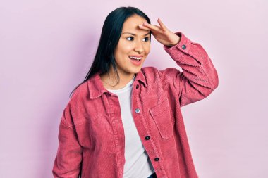 Güzel İspanyol bir kadın, burun piercingli, sıradan pembe bir ceket giyiyor çok mutlu ve gülümsüyor. arama kavramı. 