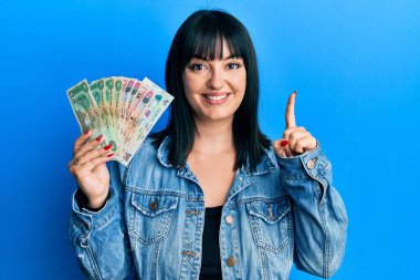 Birleşik Arap Emirlikleri 'ni elinde tutan genç İspanyol kadın gülümseyen bir fikir veya soruyla gülümsüyor. 