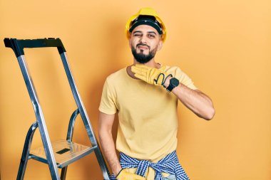 İnşaat merdivenlerinde sakallı yakışıklı bir adam bıçak niyetine boğazını kesiyor, saldırganlığı şiddetle tehdit ediyor. 