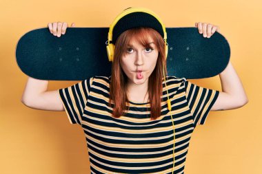 Kızıl saçlı genç kadın, kulaklık takıyor, balık suratlı, şaşı gözlü, çılgın ve komik.. 