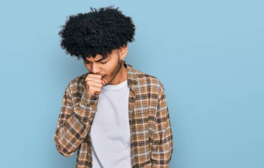 Afro saçlı, rahat giyimli, kendini iyi hissetmeyen ve soğuk algınlığı veya bronşitin belirtisi olarak öksüren Afro-Amerikalı genç bir adam. sağlık hizmeti kavramı. 