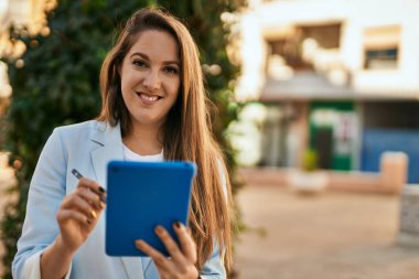 Şehirde dokunmatik ped kullanan genç sarışın iş kadını..