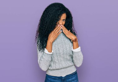 Orta yaşlı Afro-Amerikalı kadın günlük kıyafetler giyip gülüyor ve utanıyor kıkırdıyor ağızlarını ellerle, dedikoduyla ve skandal konseptiyle kapatıyor. 