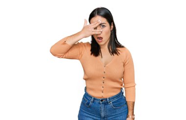 Gündelik kıyafetler giyen genç İspanyol kadın şok içinde yüzünü ve gözlerini kapayarak utanmış ifadesiyle parmaklarının arasından bakıyor.. 