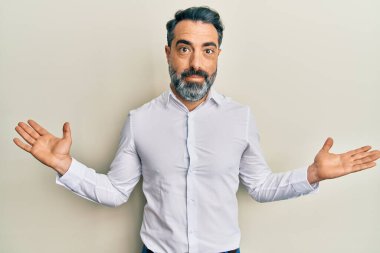 Orta yaşlı, sakallı, gri saçlı, sıradan beyaz tişörtlü, hiçbir şeyden habersiz, kolları açık, hiçbir fikri olmayan ve şüpheli yüzlü bir adam.. 