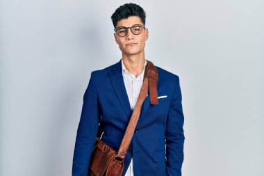 İş kıyafetleri giyen genç İspanyol adam yüzünde ciddi bir ifadeyle rahatladı. Basit ve doğal bir şekilde kameraya bakıyorsun.. 