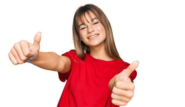 十几岁的白人女孩穿着休闲的红色T恤 赞成用手做积极的手势 微笑着竖起大拇指 为成功感到高兴 优胜手势 — 图库照片