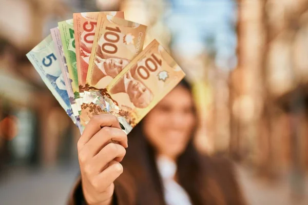 Młoda Latynoska Uśmiechnięta Szczęśliwa Trzymająca Kanadyjskie Dolary Mieście — Zdjęcie stockowe