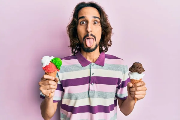 Young Hispanic Man Holding Ice Cream Sticking Tongue Out Happy — Stock Photo, Image