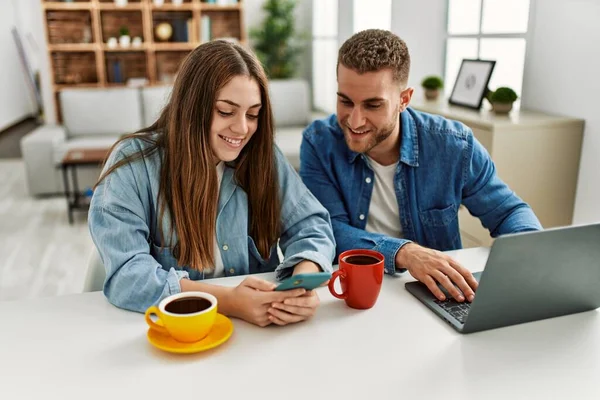 Joven Pareja Caucásica Desayunando Usando Laptop Smartphone Casa — Foto de Stock