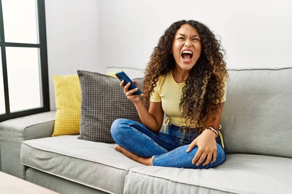 Hermosa Mujer Hispana Sentada Sofá Casa Usando Teléfono Inteligente Enojado —  Fotos de Stock