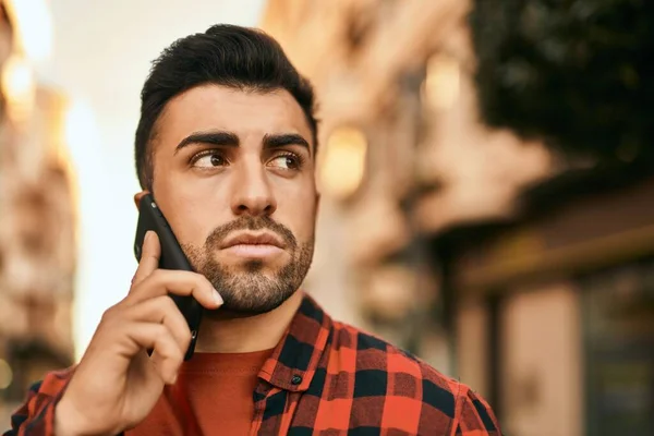 Joven Hombre Hispano Con Expresión Seria Hablando Smartphone Ciudad —  Fotos de Stock