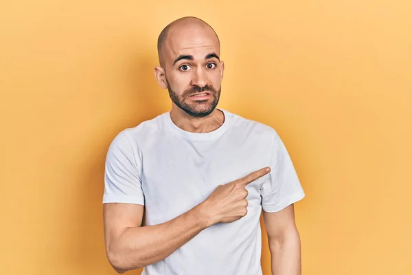 Young Bald Man Wearing Casual White Shirt Pointing Aside Worried — Foto Stock