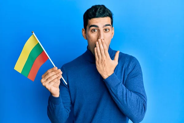 Hombre Hispano Guapo Sosteniendo Bandera Lituanía Cubriendo Boca Con Mano —  Fotos de Stock