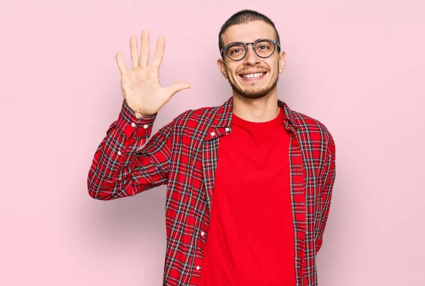 Latynoski Młodzieniec Luźnych Ubraniach Pokazujący Wskazujący Palcami Numer Pięć Uśmiechnięty — Zdjęcie stockowe