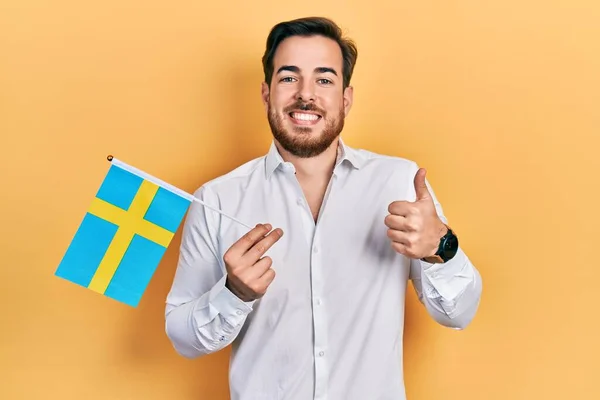 Przystojny Biały Mężczyzna Brodą Trzyma Szwedzką Flagę Uśmiechnięty Szczęśliwy Pozytywny — Zdjęcie stockowe