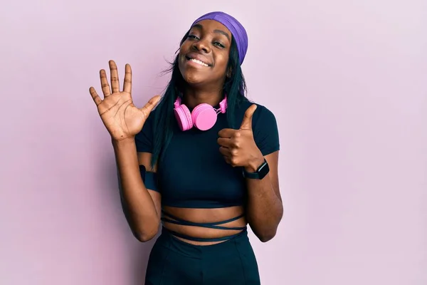 Jovem Afro Americana Vestindo Roupas Ginástica Usando Fones Ouvido Mostrando — Fotografia de Stock