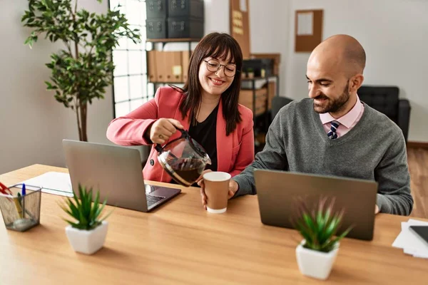 İki İspanyol iş adamı mutlu gülümsüyor. Ortağım ofiste kahve dolduruyor..