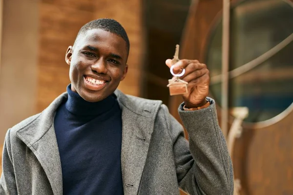 若いアフリカ系アメリカ人の男が笑顔で街で新しい家の鍵を握って — ストック写真