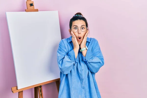 Young Hispanic Woman Standing Painter Easel Stand Afraid Shocked Surprise — Stok fotoğraf