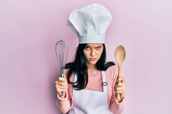 Молодая Испаноязычная Женщина Форме Пекаря Держит Ложку Взбивает Скептически Нервно — стоковое фото