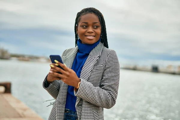 年轻的非洲裔美国女商人在港口用智能手机开心地微笑着 — 图库照片