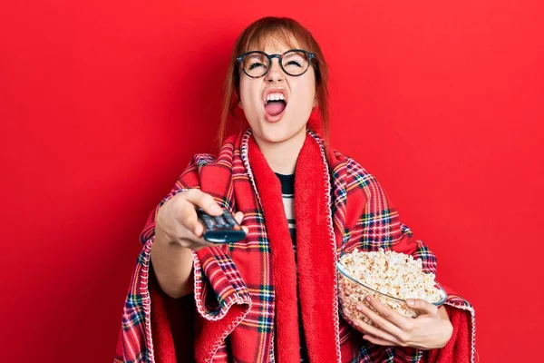 Redhead Young Woman Eating Popcorn Using Control Angry Mad Screaming — Zdjęcie stockowe