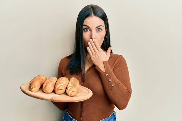 Ung Brunett Kvinna Håller Bröd Täcker Munnen Med Handen Chockad — Stockfoto