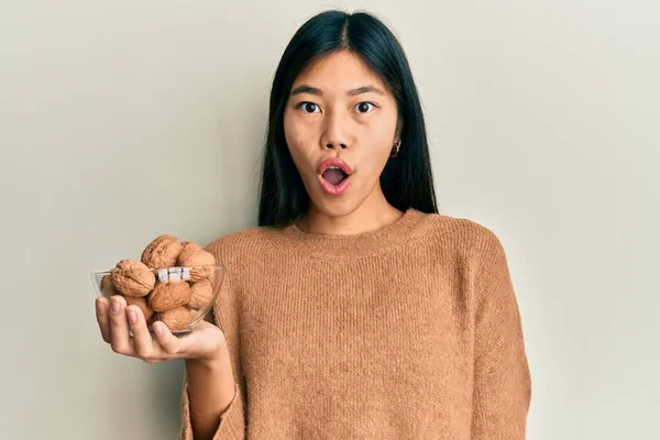 Young Chinese Woman Holding Bowl Walnuts Scared Amazed Open Mouth — Stok fotoğraf