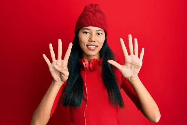 Young Chinese Woman Listening Music Using Headphones Showing Pointing Fingers — Foto Stock