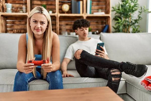 Casal Jovem Sorrindo Feliz Jogando Videogame Usando Smartphone Casa — Fotografia de Stock