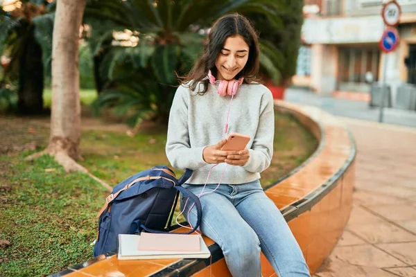 若いです中東学生女の子笑顔幸せな使用スマートフォンで市内 — ストック写真