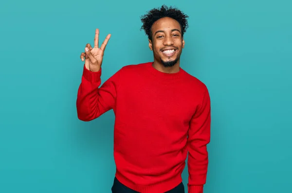 年轻的非洲裔美国人 留着胡子 穿着休闲地冬季毛衣 手指头指向二号 面带微笑 自信而快乐 — 图库照片