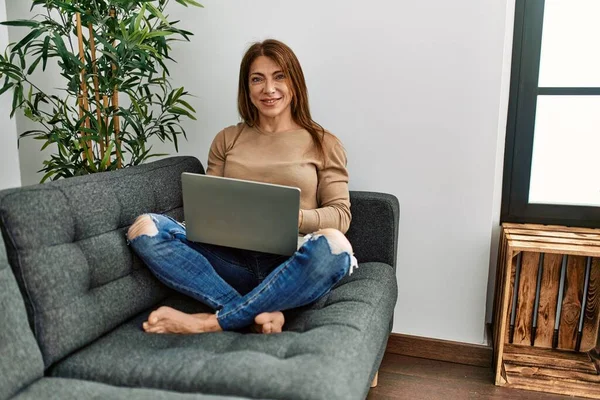 Senior Mulher Oriente Médio Usando Laptop Sentado Sofá Casa Olhando — Fotografia de Stock