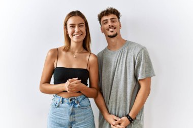 Genç ve güzel bir çift el ele tutuşmuş ve mutlu bir şekilde gülümsüyor. Başarı ve iyimserlik 