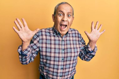 Gri saçlı, sıradan tişörtlü yakışıklı bir adam çılgın kutlamalar yapıyor ve kolları açık, gözleri açık heyecanla haykırarak başarıyı kutluyor. Kazanan konsept 