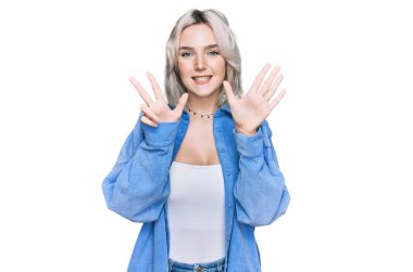 Gündelik kıyafetler giyen genç sarışın kız sekiz numarayı gösterip işaret ederken kendinden emin ve mutlu gülümsüyor.. 