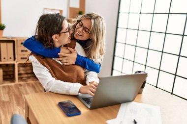 Ofiste çalışırken gülümseyen iki iş kadını..