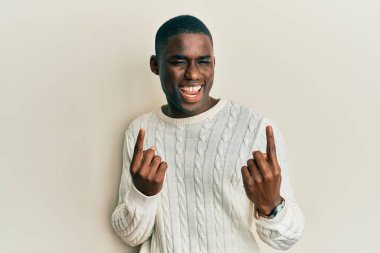 Young african american man wearing casual clothes showing middle finger doing fuck you bad expression, provocation and rude attitude. screaming excited 