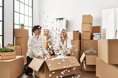 Genç ve güzel bir çift gülümsüyor. Yeni evlerinde köpükle oynuyorlar..