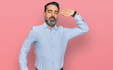 Orta yaşlı, sakallı, iş gömleği giyen, gerinen, yorgun ve rahat, uykulu ve sabahın erken saatleri için esneyen bir adam. 