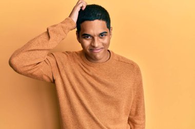 Kış süveteri giyen genç, yakışıklı İspanyol adam soru sorup şaşırıyor. Şüpheyle kararsız, kafa kafaya düşünerek. Düşünceli kavram. 