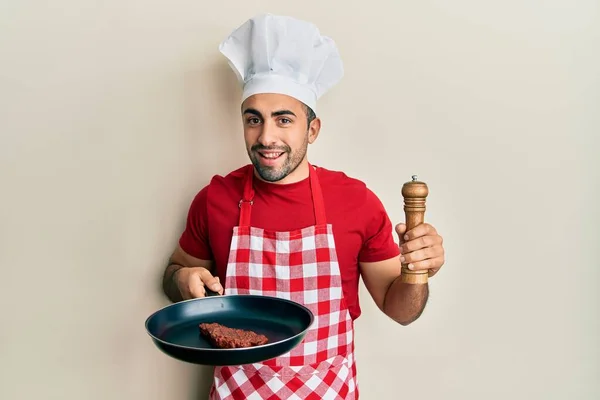 Mladý Hispánec Profesionální Kuchařské Uniformě Klobouku Hovězím Úsměvem Tváři Zobrazování — Stock fotografie