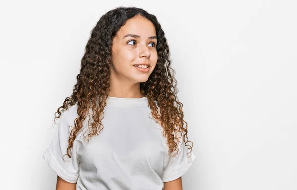 10代のヒスパニック系の女の子の顔に笑顔で横に見てカジュアルな白いTシャツを着て 自然な表情 自信を持って — ストック写真
