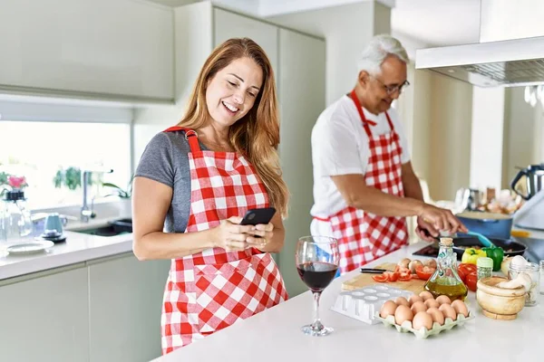 Orta Yaşlı Spanyol Çift Gülümsüyor Mutfakta Yemek Pişiriyor Akıllı Telefon — Stok fotoğraf