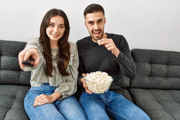 Unga Latinamerikanska Par Tittar Film Och Äter Popcorn Sittandes Soffan — Stockfoto