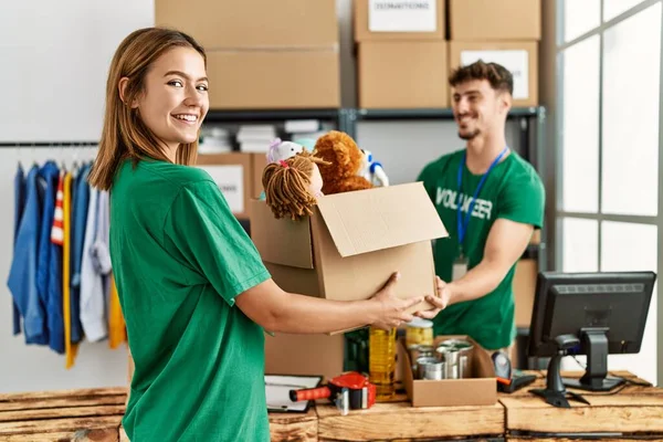 Joven Pareja Hispana Voluntaria Sonriendo Feliz Dando Caja Con Juguetes —  Fotos de Stock