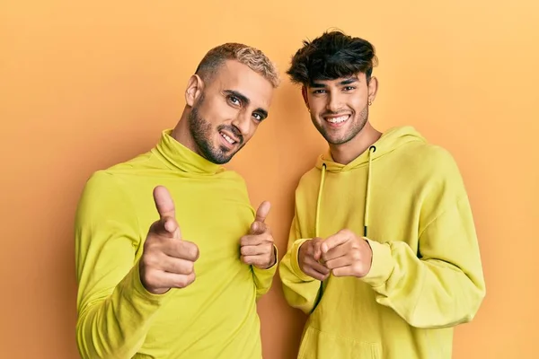 Homosexual Pareja Gay Pie Juntos Usando Ropa Amarilla Señalando Los —  Fotos de Stock